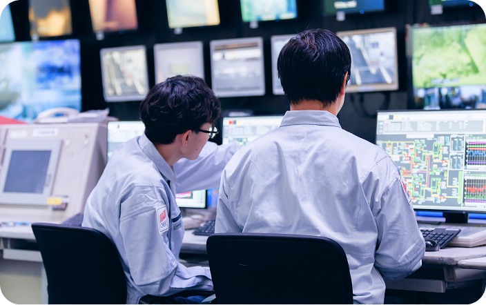施設のモニターを確認する技術職の社員